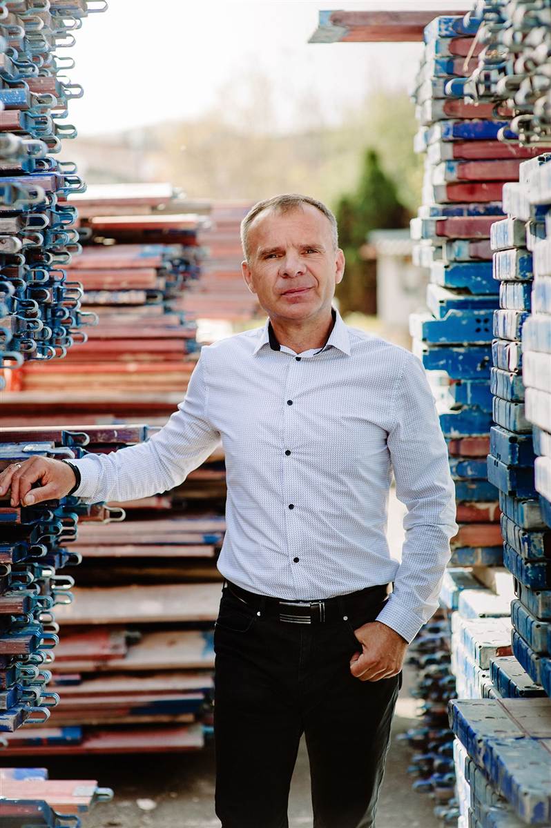 Roman Masternak sprawdza elementy rusztowania w magazynie
