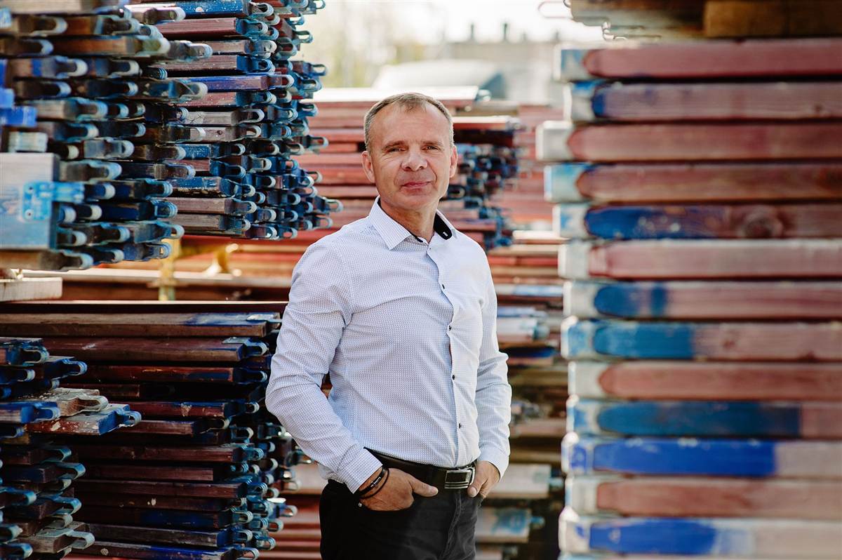 Roman Masternak przy składowanych elementach rusztowania